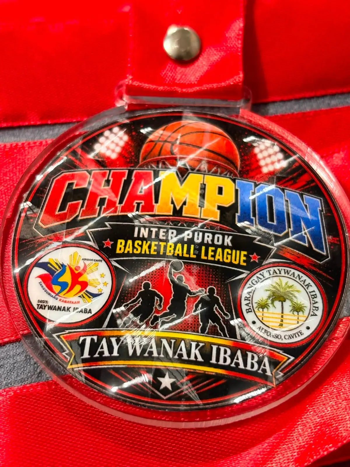 Close view of an acrylic champion medal on a red ribbon