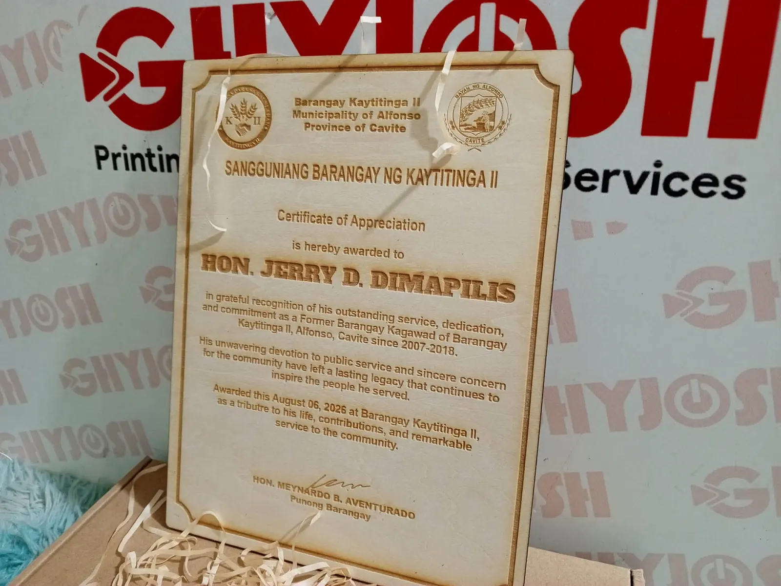 Light wood certificate engraved with a barangay citation and two seals