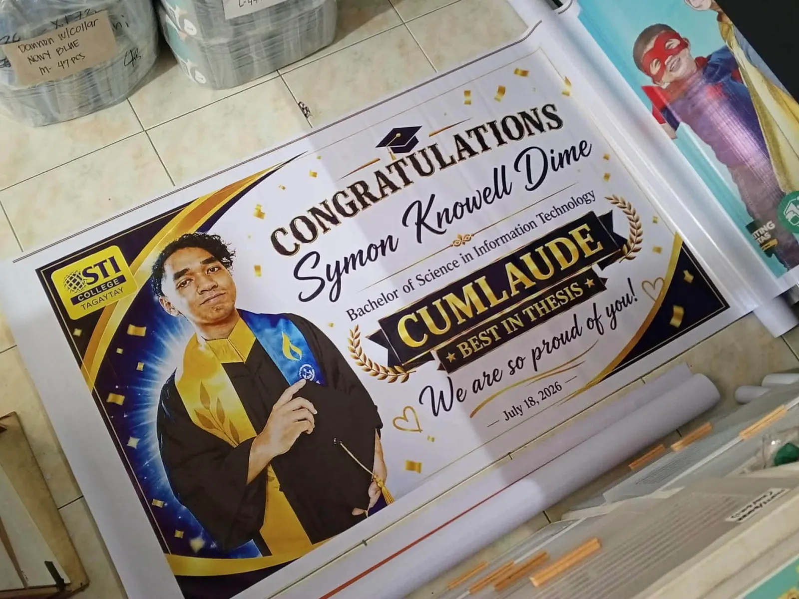 Graduation tarpaulin with a portrait in academic dress and gold lettering