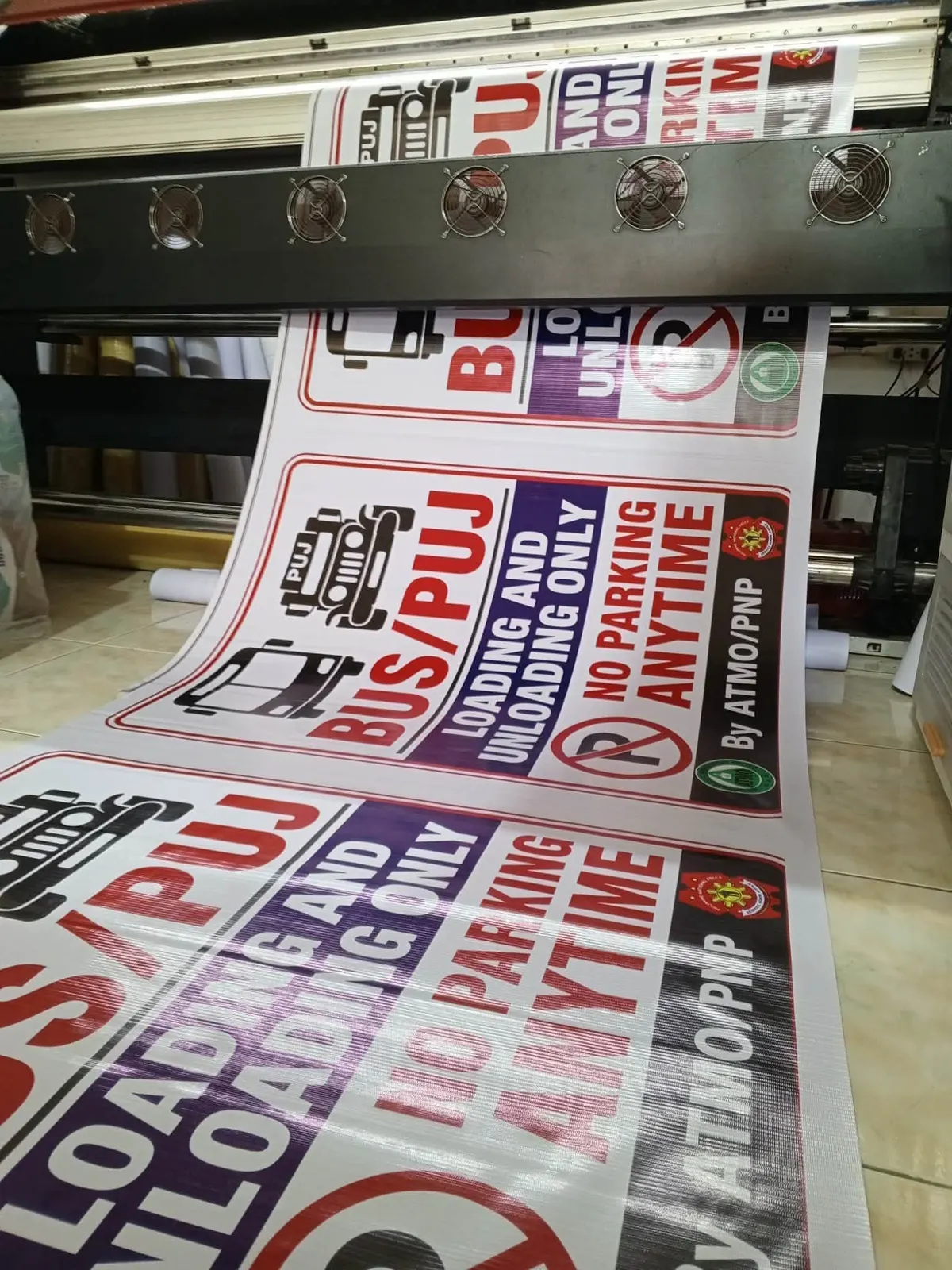 Large-format printer running a roll of parking and loading signs