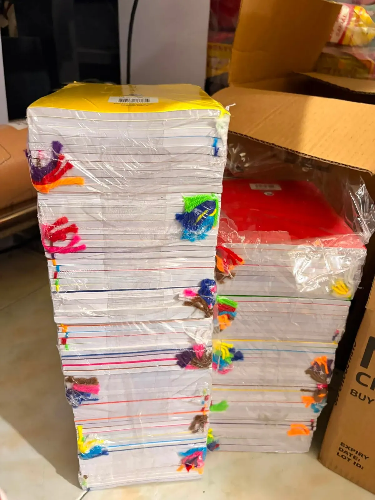 Tall stacks of wrapped notebooks with colored yarn ties